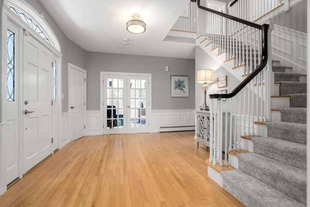 267 W St, Northborough, MA 01532 - entrance foyer featuring baseboard heating, a decorative wall, wood finished floors, stairs, and healthy amount of natural light