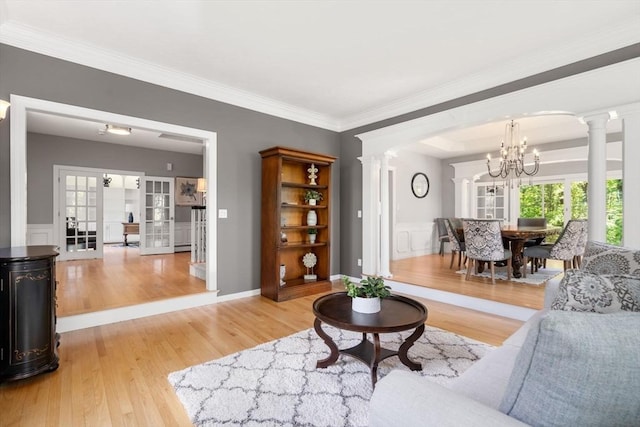 267 W St, Northborough, MA 01532 - living room with decorative columns, a chandelier, light wood finished floors, plenty of natural light, and a decorative wall