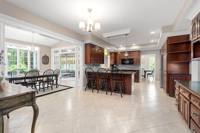 267 W St, Northborough, MA 01532 - kitchen featuring a chandelier, black microwave, a kitchen bar, dark countertops, and light tile patterned floors