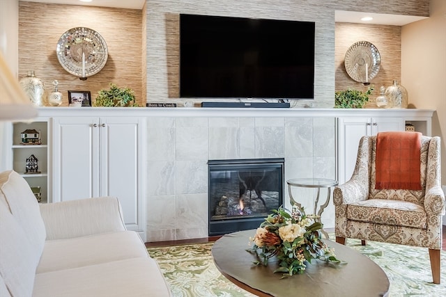 living room featuring built in features and a tile fireplace