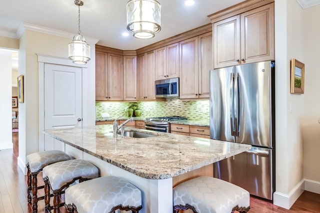 kitchen featuring hardwood / wood-style floors, stainless steel appliances, a kitchen island with sink, and sink