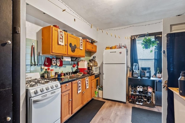 222-R Kimball St, Fitchburg, MA 01420 - kitchen featuring white appliances, light wood-style floors, brown cabinetry, and dark countertops