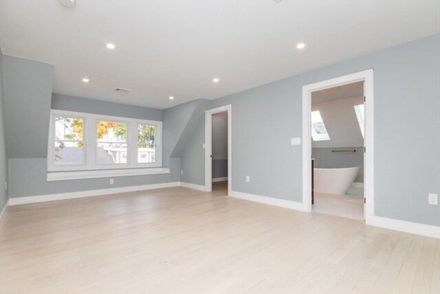 interior space featuring light hardwood / wood-style floors and a skylight