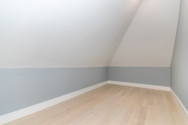 additional living space featuring lofted ceiling and hardwood / wood-style floors