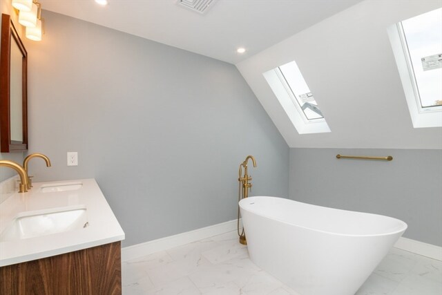 bathroom featuring vanity, a bathtub, and vaulted ceiling