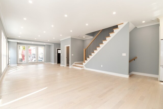 unfurnished living room with ornamental molding and light wood-type flooring