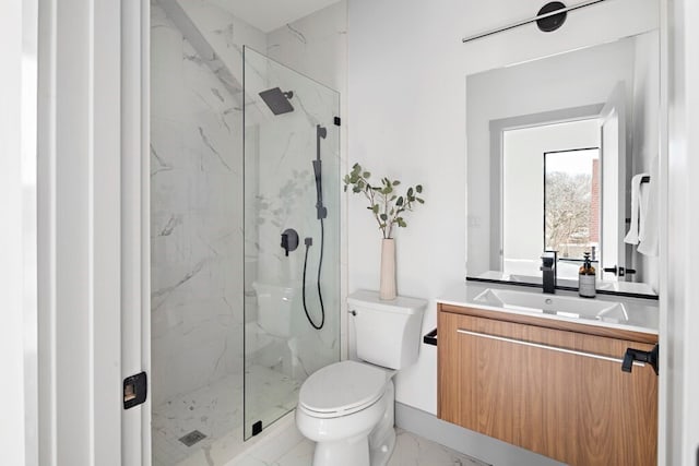 bathroom with vanity, toilet, and tiled shower