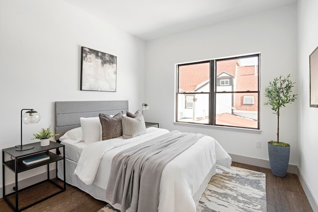 bedroom with dark wood-type flooring and multiple windows