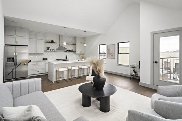 living room featuring high vaulted ceiling and wood-type flooring