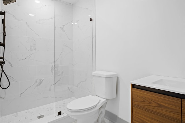 bathroom with vanity, toilet, and a tile shower