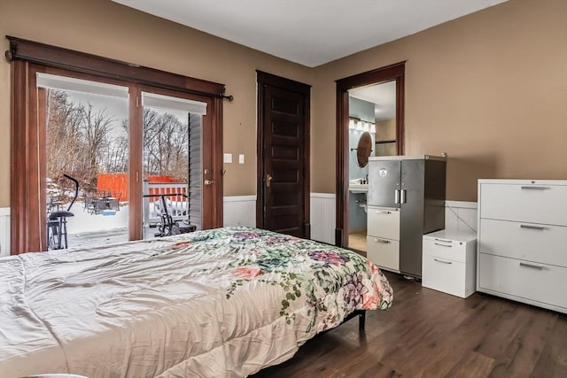 bedroom featuring access to outside, wainscoting, and dark wood finished floors