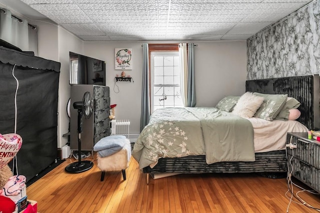 bedroom with wood finished floors and radiator