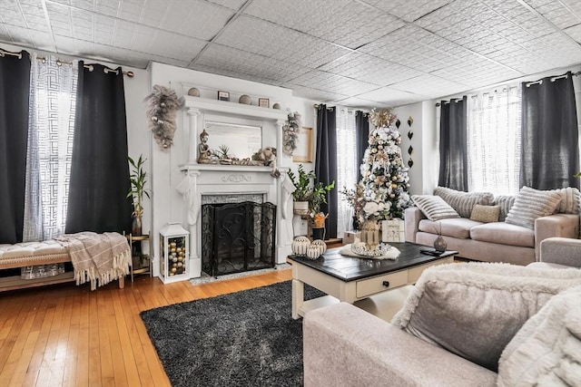 living area with a fireplace with flush hearth and wood finished floors