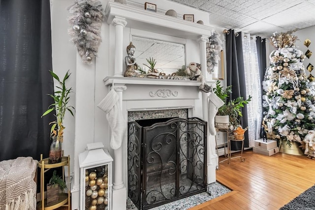 living room with a fireplace with flush hearth and wood finished floors