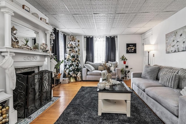 living room with wood finished floors and a high end fireplace