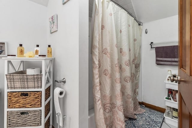 full bath featuring shower / tub combo with curtain, tile patterned flooring, and baseboards