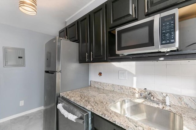 kitchen with tasteful backsplash, electric panel, sink, stainless steel appliances, and light stone counters