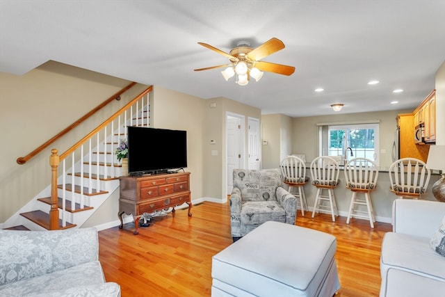 living room with light wood-type flooring and ceiling fan