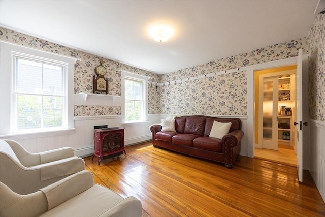 75 Union St, Holliston, MA 01746 - living area with a wainscoted wall, hardwood / wood-style floors, a baseboard radiator, wallpapered walls, and a wood stove