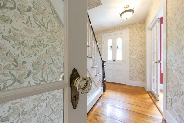75 Union St, Holliston, MA 01746 - foyer entrance featuring light wood-type flooring, baseboard heating, wallpapered walls, and stairs