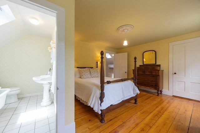 75 Union St, Holliston, MA 01746 - bedroom with ensuite bathroom, wallpapered walls, lofted ceiling, a skylight, and light wood-type flooring