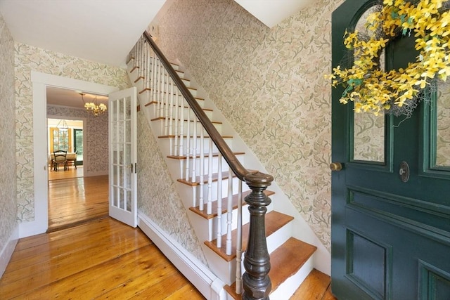 75 Union St, Holliston, MA 01746 - staircase with wood-type flooring, wallpapered walls, and a chandelier