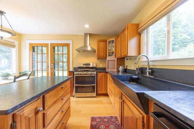 75 Union St, Holliston, MA 01746 - kitchen featuring wall chimney exhaust hood, range with two ovens, dark countertops, brown cabinets, and light wood-style flooring