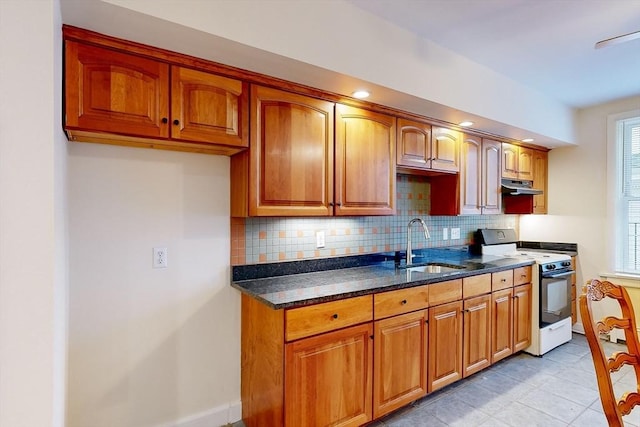 2 Waumbeck St, Boston, MA 02121 - kitchen with dark stone countertops, white stove, decorative backsplash, sink, and light tile patterned flooring