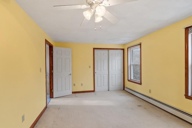 unfurnished bedroom with a ceiling fan, baseboards, a closet, carpet flooring, and baseboard heating