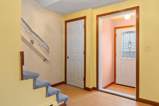 foyer featuring stairway, light wood-style floors, and baseboards