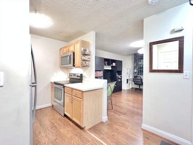 kitchen with light brown cabinets, light hardwood / wood-style floors, and appliances with stainless steel finishes