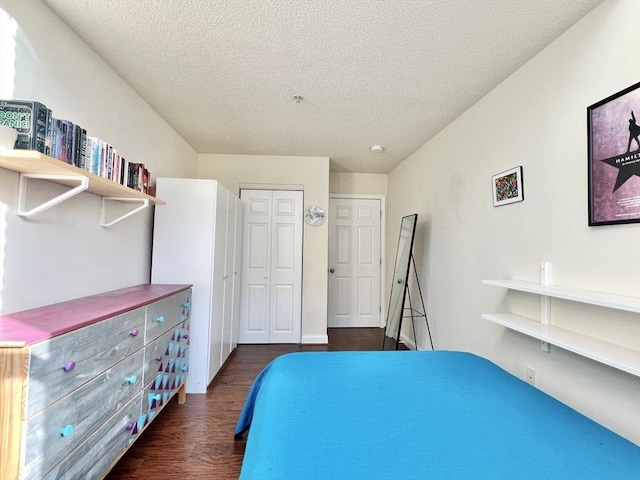 bedroom with a textured ceiling and dark hardwood / wood-style floors