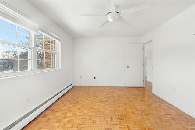 spare room with ceiling fan, light parquet floors, and a baseboard heating unit