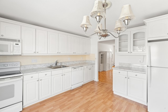 kitchen with white appliances, white cabinetry, sink, decorative light fixtures, and light hardwood / wood-style flooring