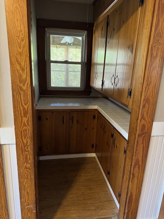 252-256 Billings St, Quincy, MA 02169 - kitchen with tile countertops, wood finished floors, and brown cabinetry