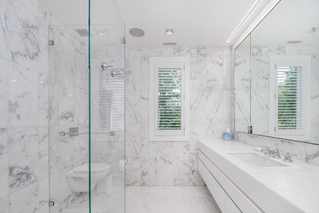 bathroom with tile floors, tile walls, a shower with door, vanity, and toilet