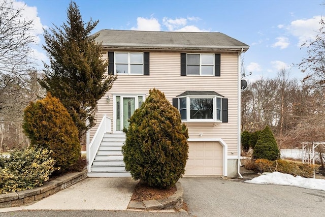 view of front of home featuring aphalt driveway, stairway, and an attached garage