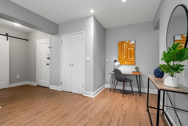 interior space with a barn door and light hardwood / wood-style flooring