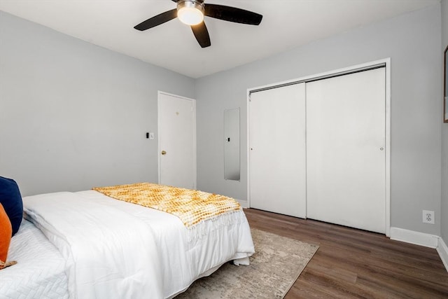 bedroom featuring dark wood-type flooring, ceiling fan, and a closet