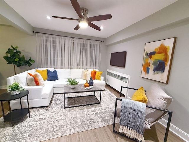 living room with radiator heating unit, ceiling fan, and hardwood / wood-style floors