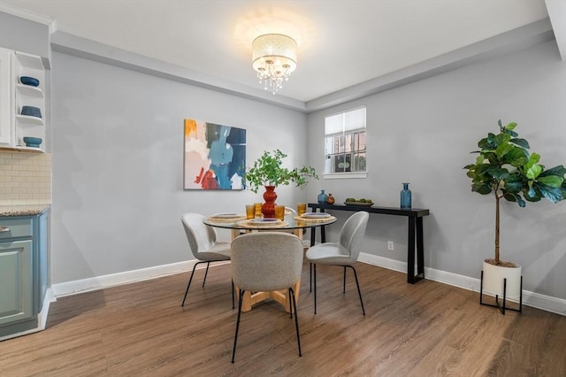 dining space with hardwood / wood-style flooring and a chandelier