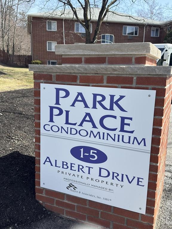 community / neighborhood sign featuring fence