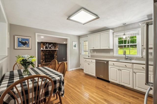 24 S Loomis St, Southwick, MA 01077 - kitchen with dishwasher, light countertops, a sink, light wood finished floors, and white cabinets