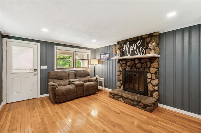 24 S Loomis St, Southwick, MA 01077 - living area with crown molding, hardwood / wood-style flooring, baseboards, a stone fireplace, and a decorative wall