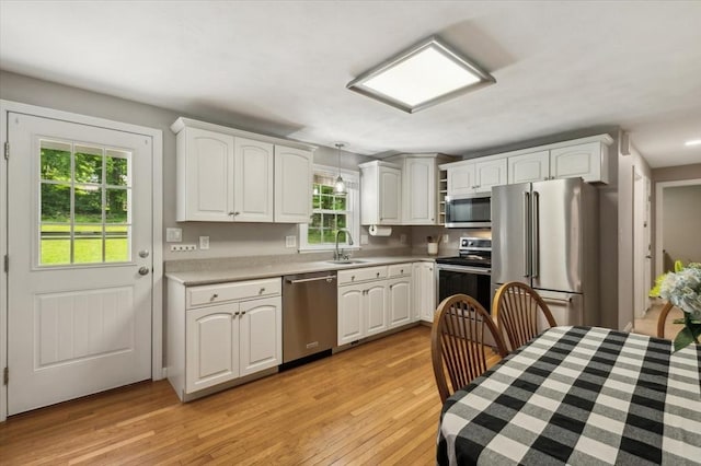 24 S Loomis St, Southwick, MA 01077 - kitchen featuring appliances with stainless steel finishes, a sink, light wood finished floors, pendant lighting, and white cabinets