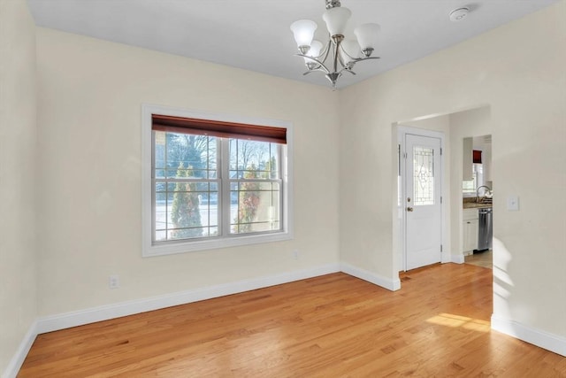 interior space featuring sink, a notable chandelier, and light hardwood / wood-style flooring