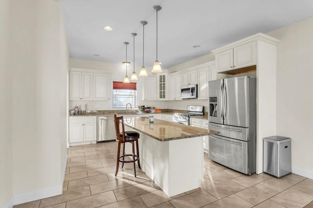 kitchen with white cabinetry, appliances with stainless steel finishes, a kitchen island, and light tile patterned floors