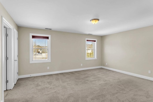 empty room with a healthy amount of sunlight and light colored carpet