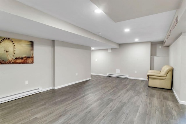 basement featuring hardwood / wood-style floors and a baseboard heating unit