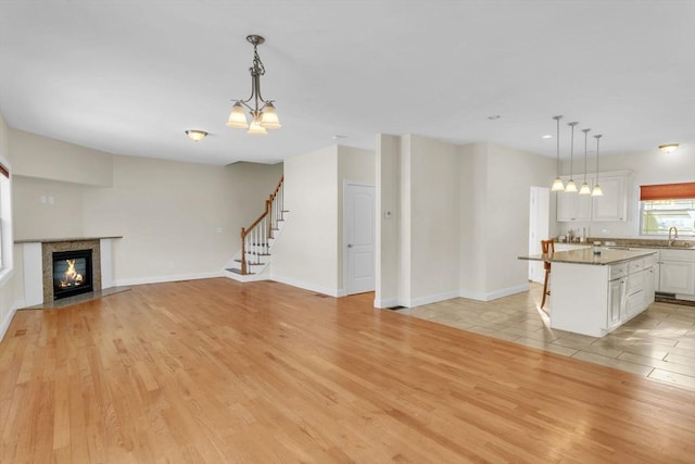 unfurnished living room with sink and light wood-type flooring